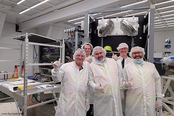 Picture of the VTF team in front of the VTF in the optics laboratory at the DKIST telescope.